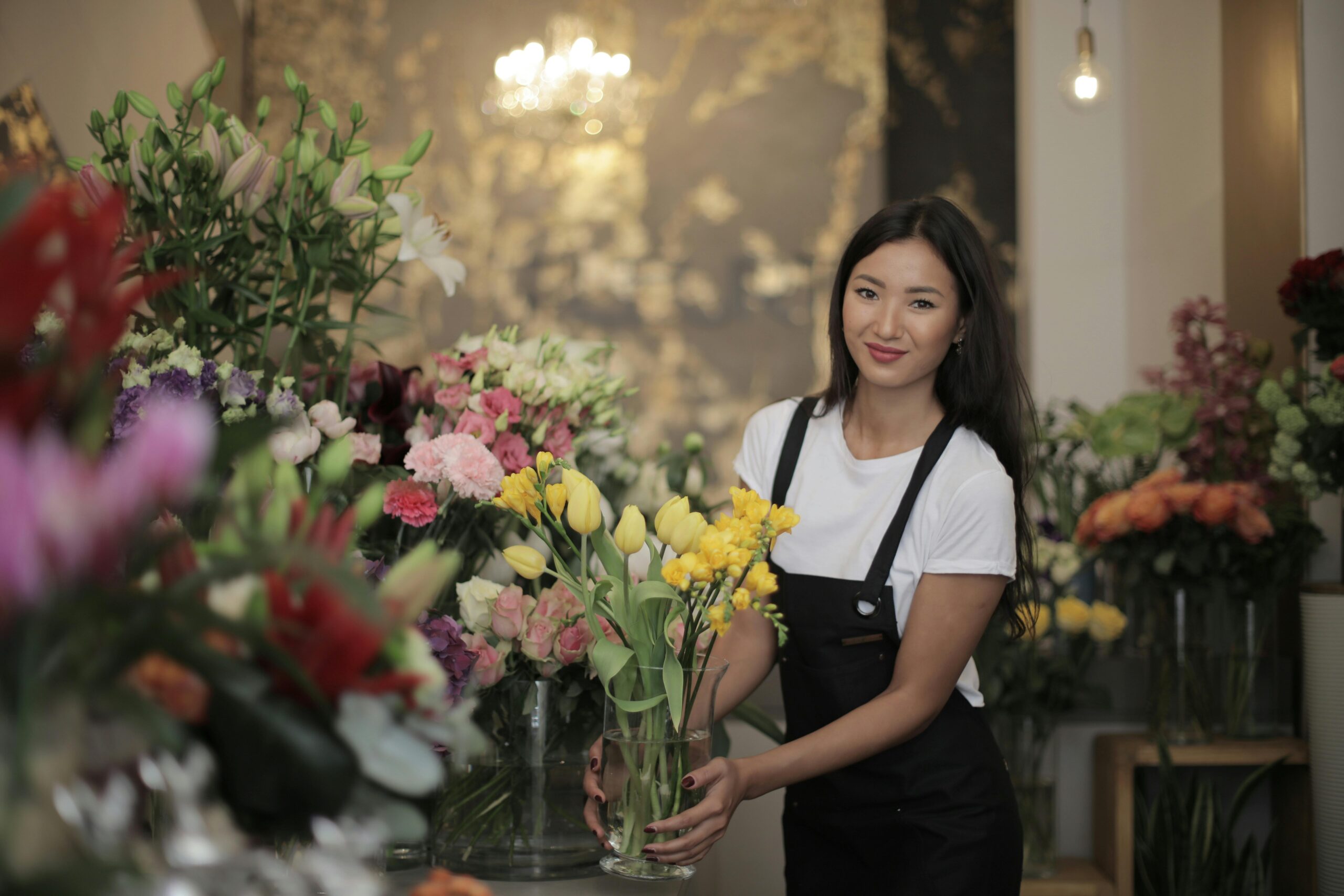 Florist in shop arranging vibrant flower bouquet with various blooms and colors. Perfect for decoration ideas.